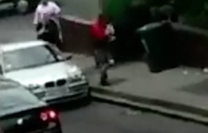 The man in the red top suddenly grabs the pet pooch and slowly begins running away