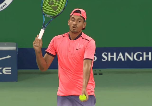 Nick Kyrgios pats a serve over the net in his disgraceful defeat