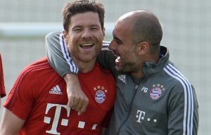 epa05095150 Munich's head coach Pep Guardiola embraces Xabi Alonso during a training session in Doha, Qatar, 10 January 2016. In front of them are teammates Javier Martinez (L) and Robert Lewandowski. Bayern Munich is scheduled to stay in Qatar until 12 January 2016 to prepare for the second half of the German Bundesliga season. EPA/ANDREAS GEBERT