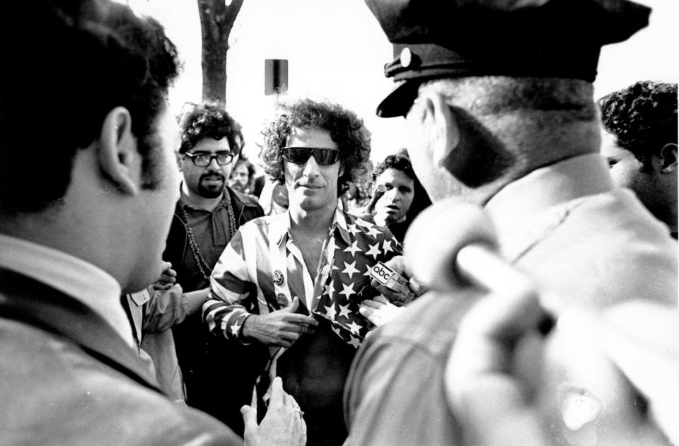 Abbie Hoffman, one of the Chicago 7, photographed after being stopped by police wearing a shirt of the American flag