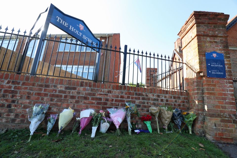 Floral tributes are left at the school where victim James Furlong taught