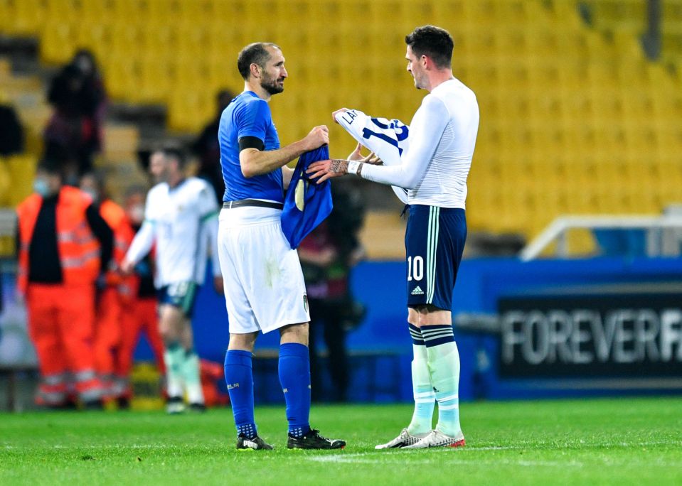 Two soccer players exchanging jerseys after a game.