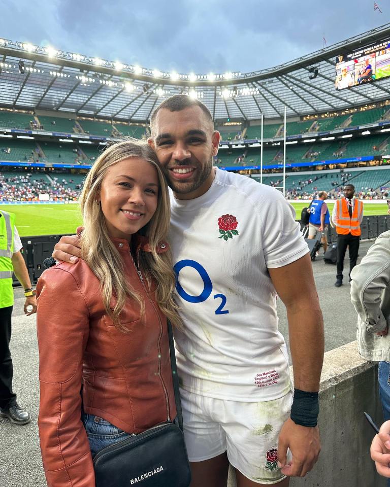 Photo of a man and woman at a rugby stadium.