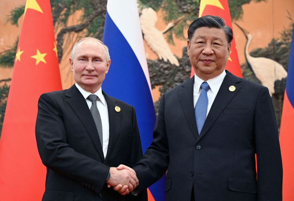 a man in a suit shakes hands with a man in a tie
