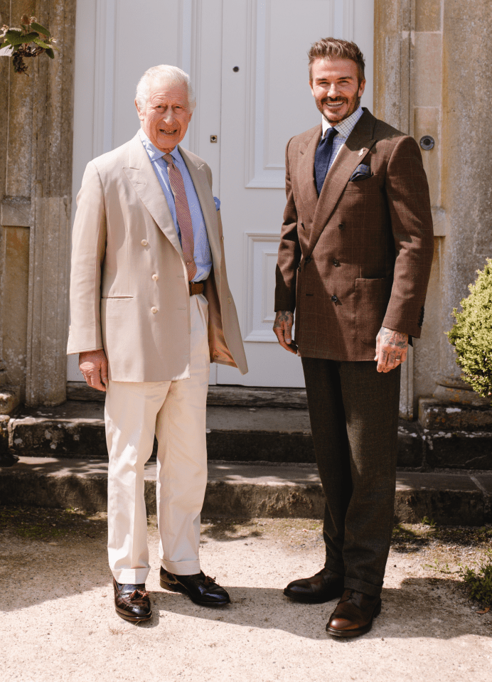 two men in suits stand in front of a white door