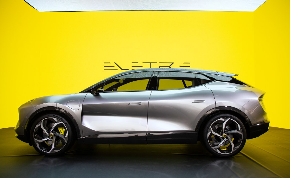 a silver car is parked in front of a yellow wall that says electra
