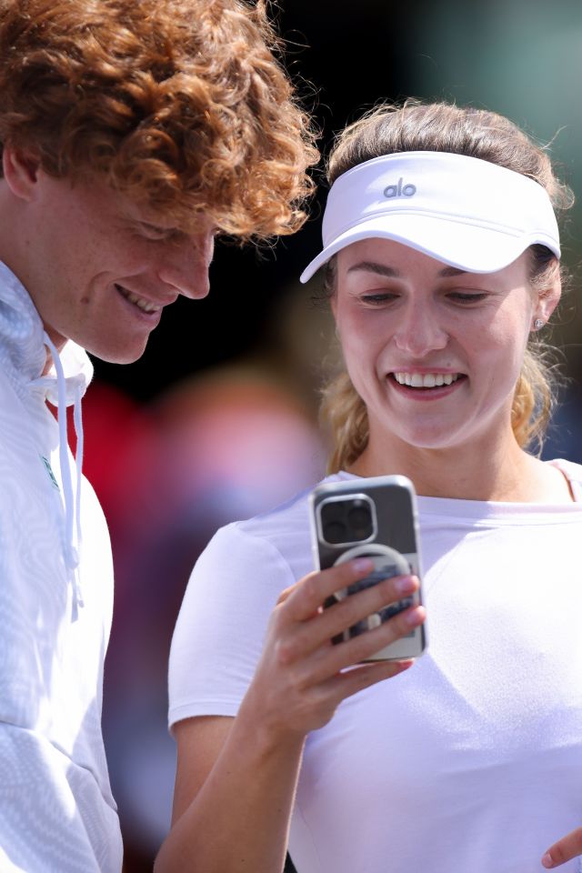a woman wearing an alo visor looks at her phone
