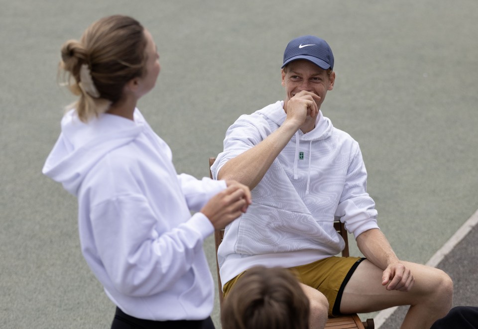 a man wearing a nike hat laughs while a woman looks on