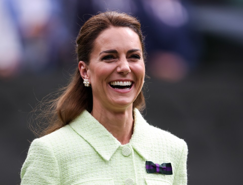 a woman wearing pearls and a green jacket is smiling