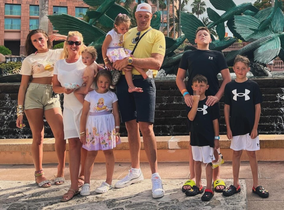 a family standing in front of a fountain wearing under armour shirts