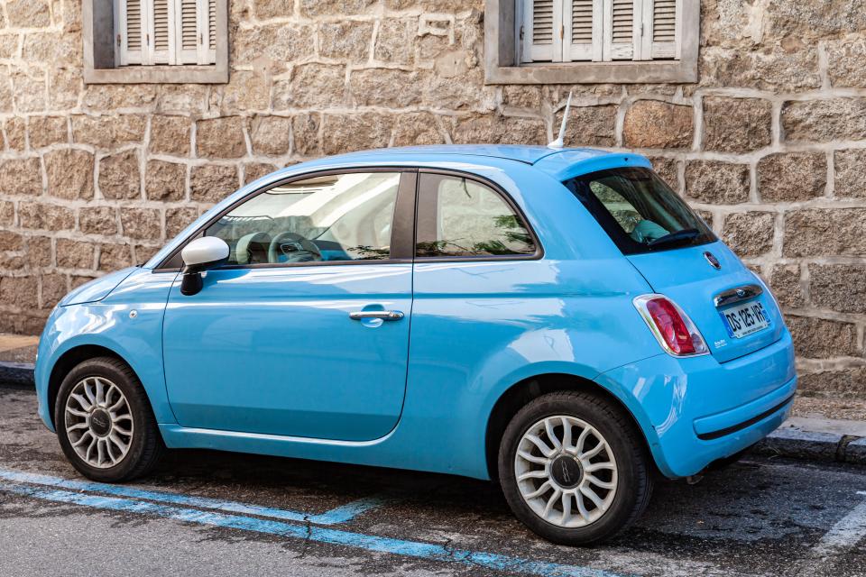 a blue car is parked in a handicapped parking spot