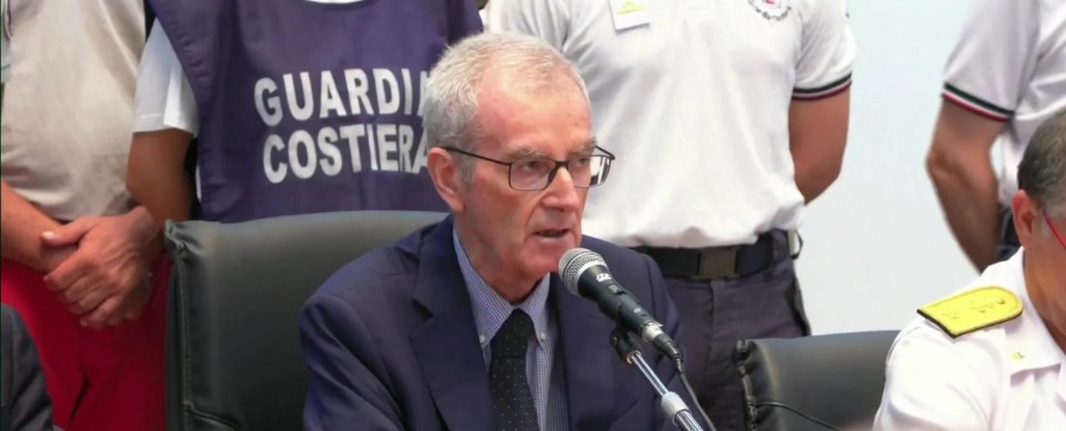 a man speaking into a microphone with a breaking news headline