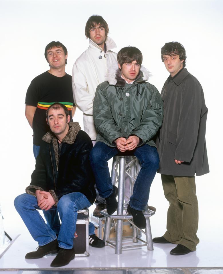a group of men posing for a picture with one man sitting on a stool