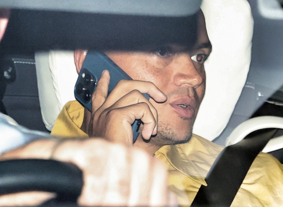 a man sitting in a car talking on a cell phone