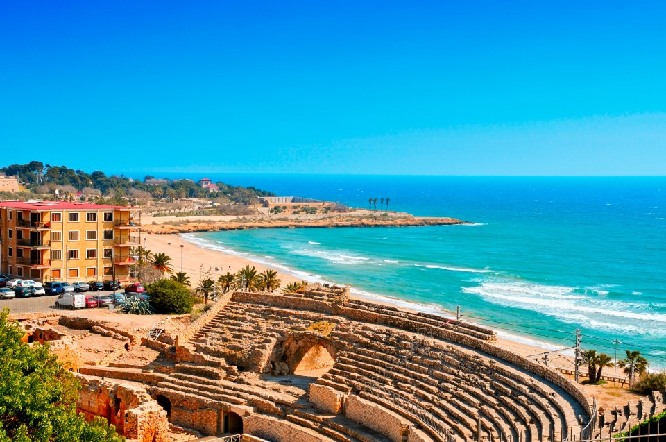 an amphitheater sits on the shore of a beach