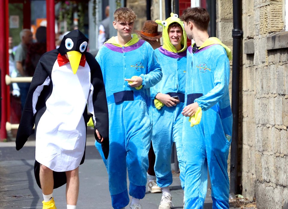 a man in a penguin costume talks to another man in a toy story costume