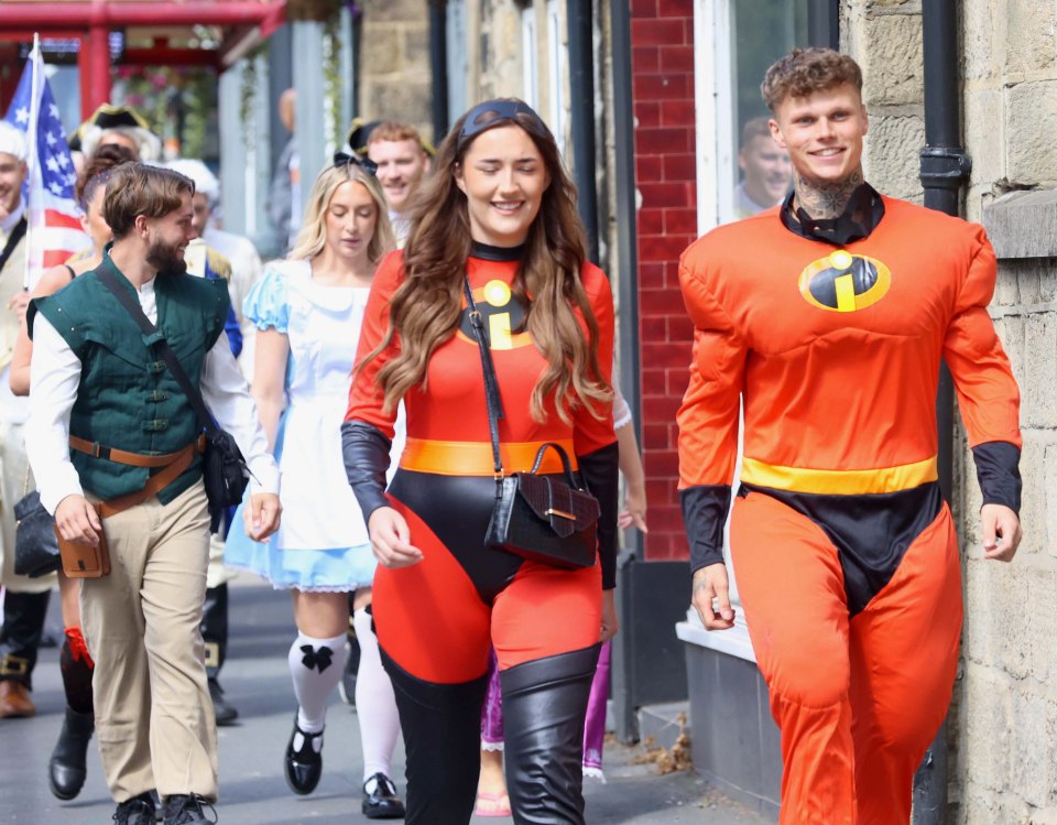 a group of people dressed in costumes are walking down a street