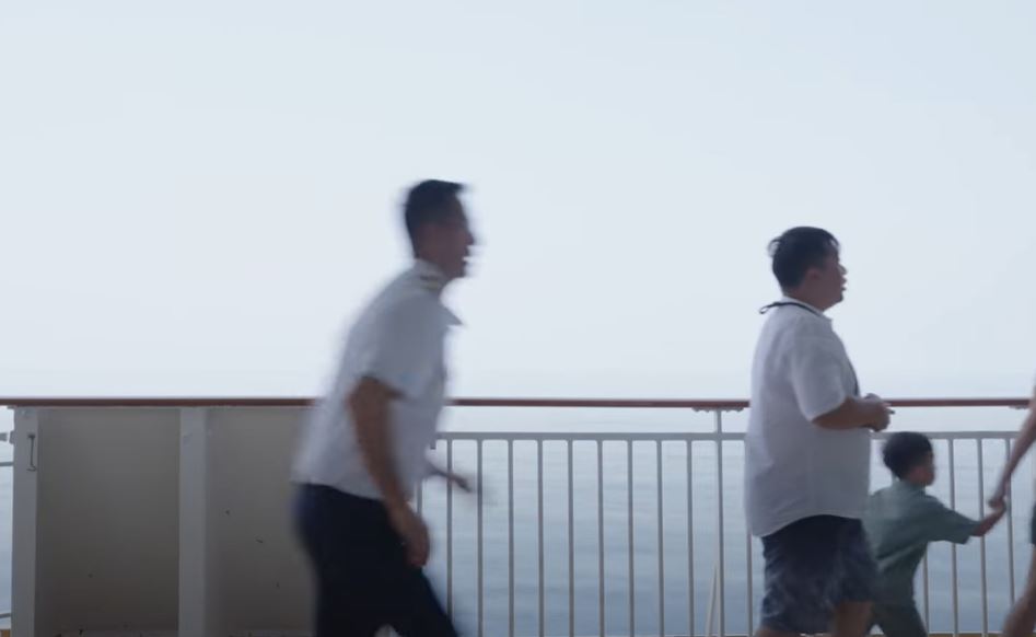a group of people walking on a balcony overlooking the ocean