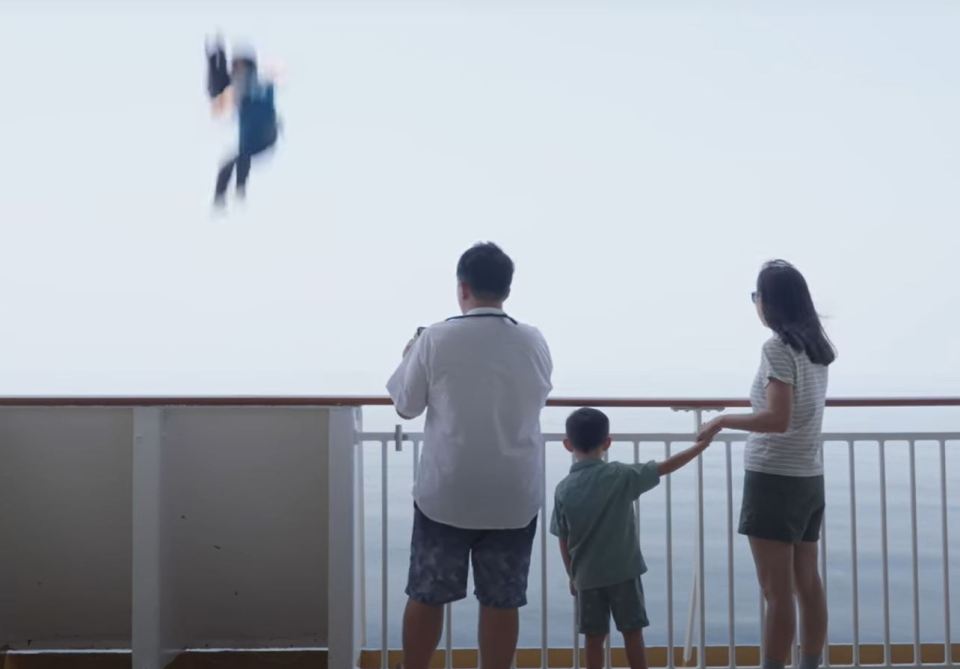 a family standing on a balcony looking at a person flying through the air