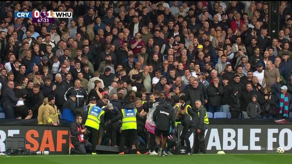 a crowd of people watching a soccer game with a sign that says safe