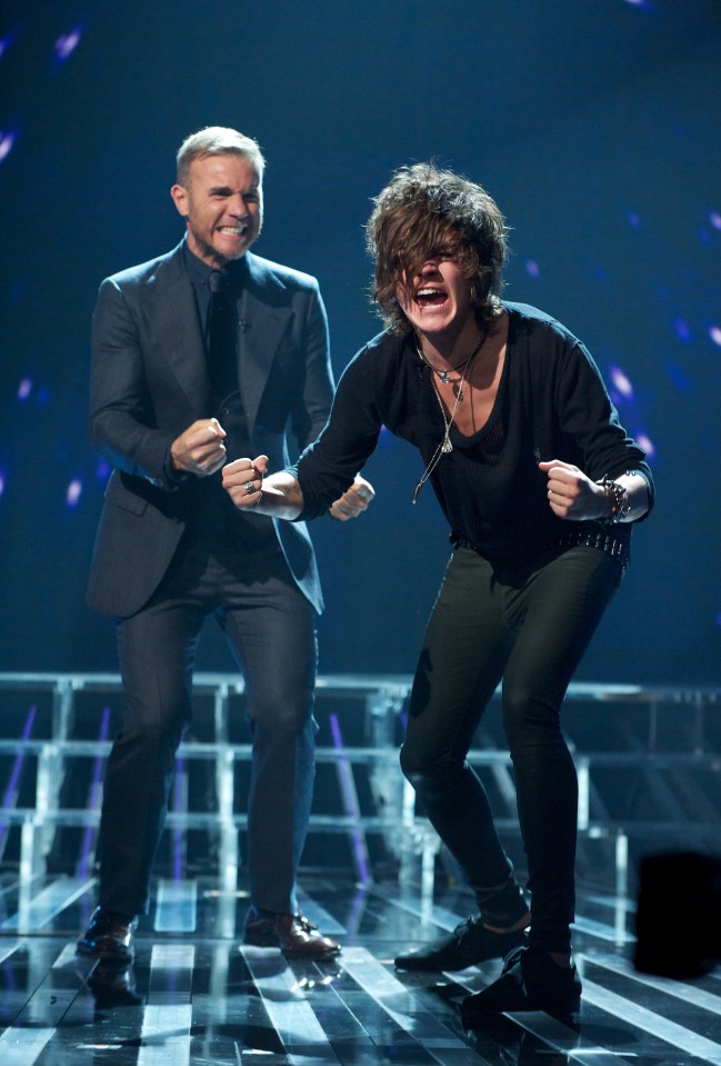 a man in a suit and a woman in a black shirt are dancing on a stage