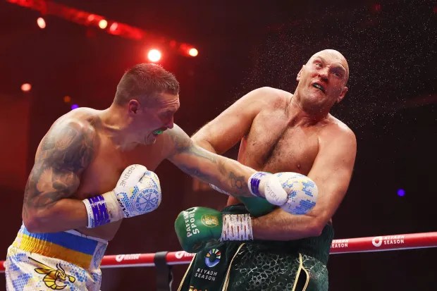 two men in boxing gloves are fighting in a ring .