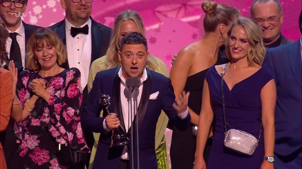 a group of people standing around a man in a suit