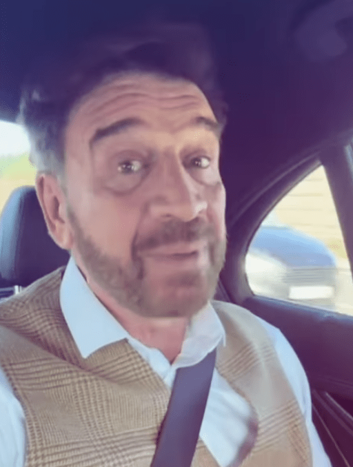 a man with a beard is sitting in the back seat of a car