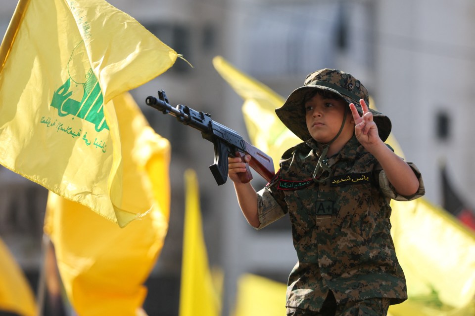 A child gestures as Hezbollah supporters gather to attend a ceremony to honour fighters killed in the recent conflict with Israel