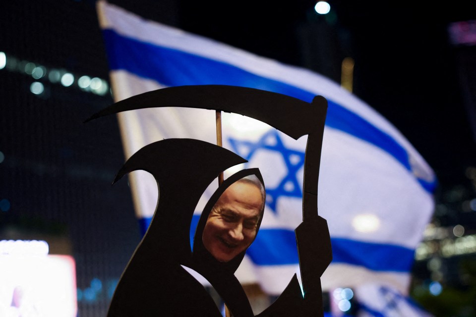 a grim reaper holding a scythe in front of a flag