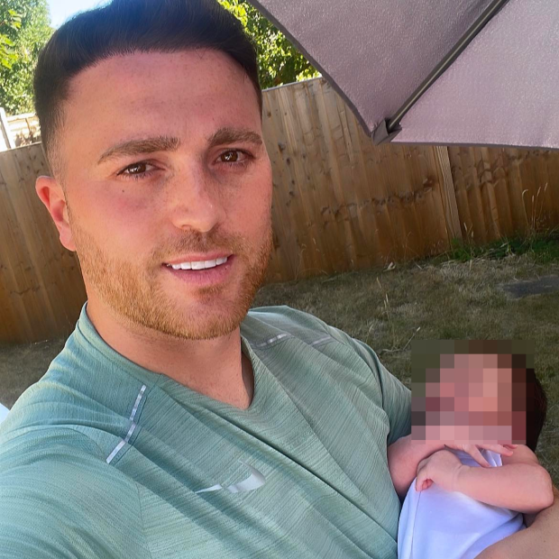 a man in a green shirt is holding a baby
