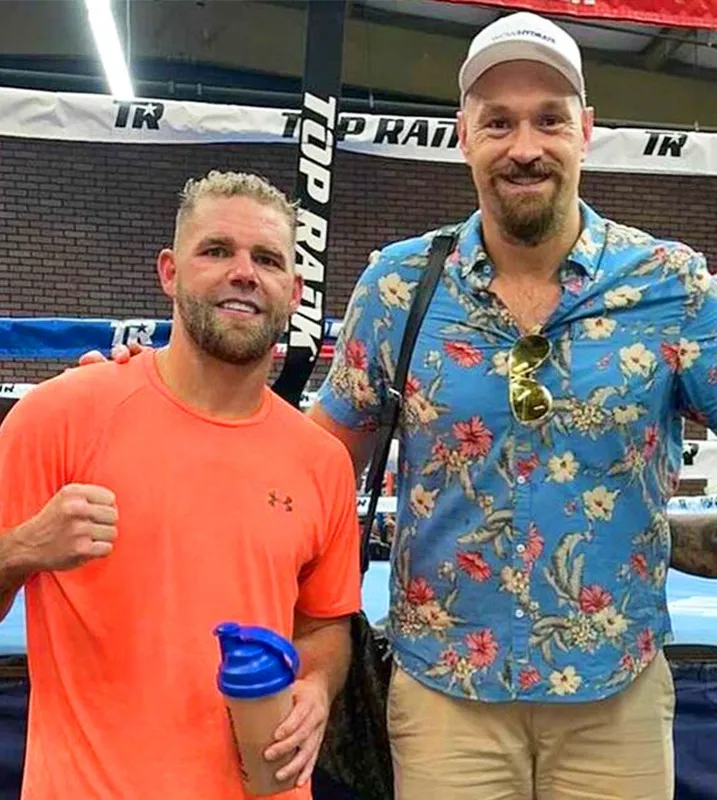 two men are posing for a picture in front of a sign that says top rank