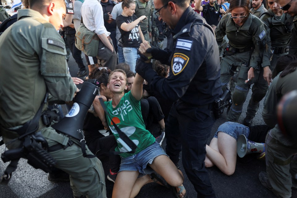 a woman wearing a green shirt that says ' שלום ' on it