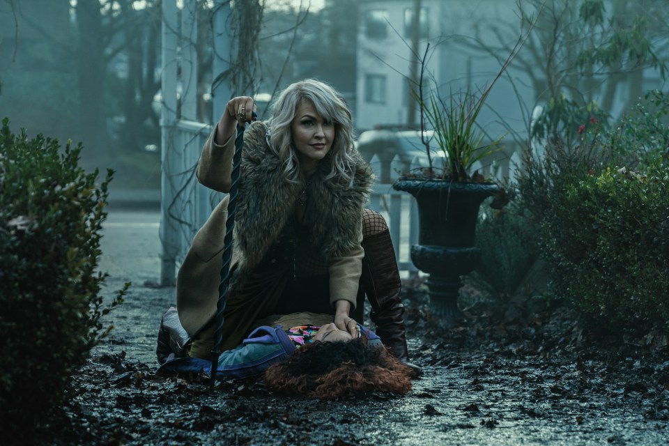 a woman laying on the ground with a cane in her hand