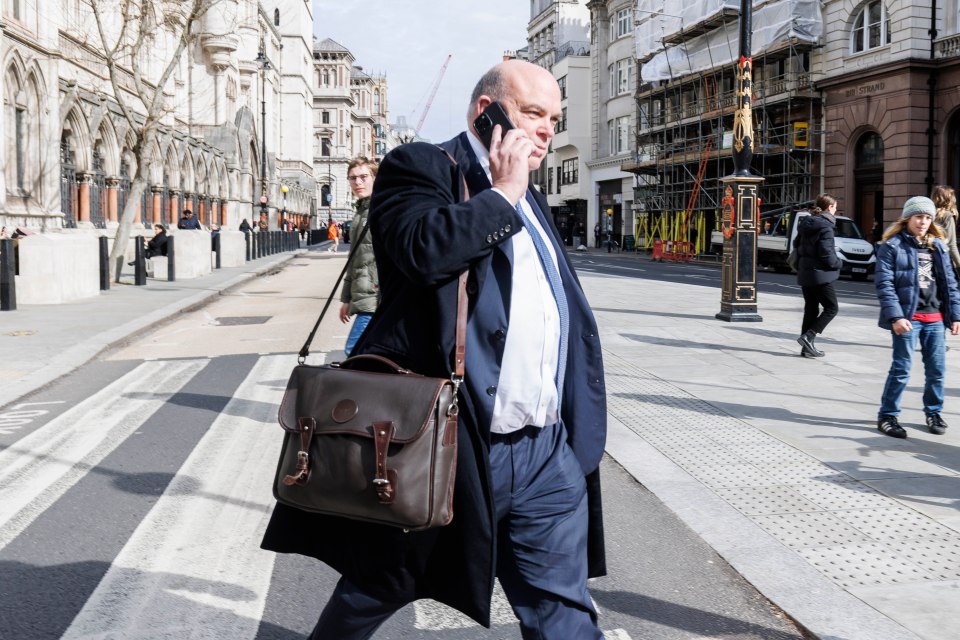 a man walking down a street talking on a cell phone