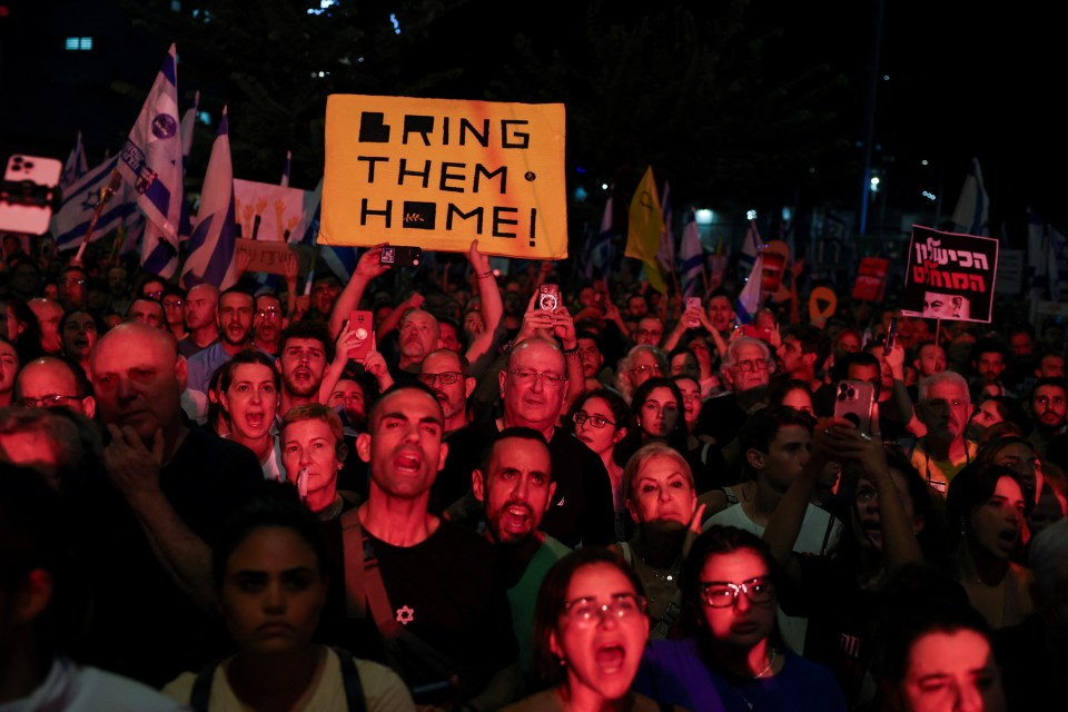 a crowd of people holding a sign that says bring them home