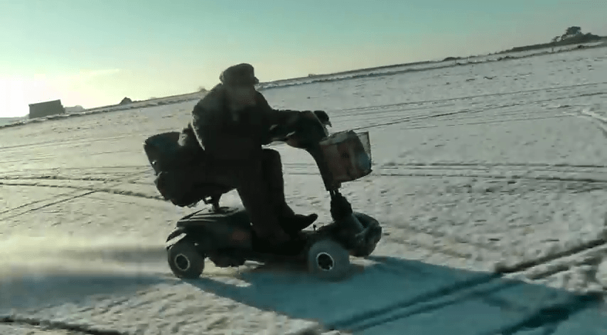a man is riding a mobility scooter in the snow