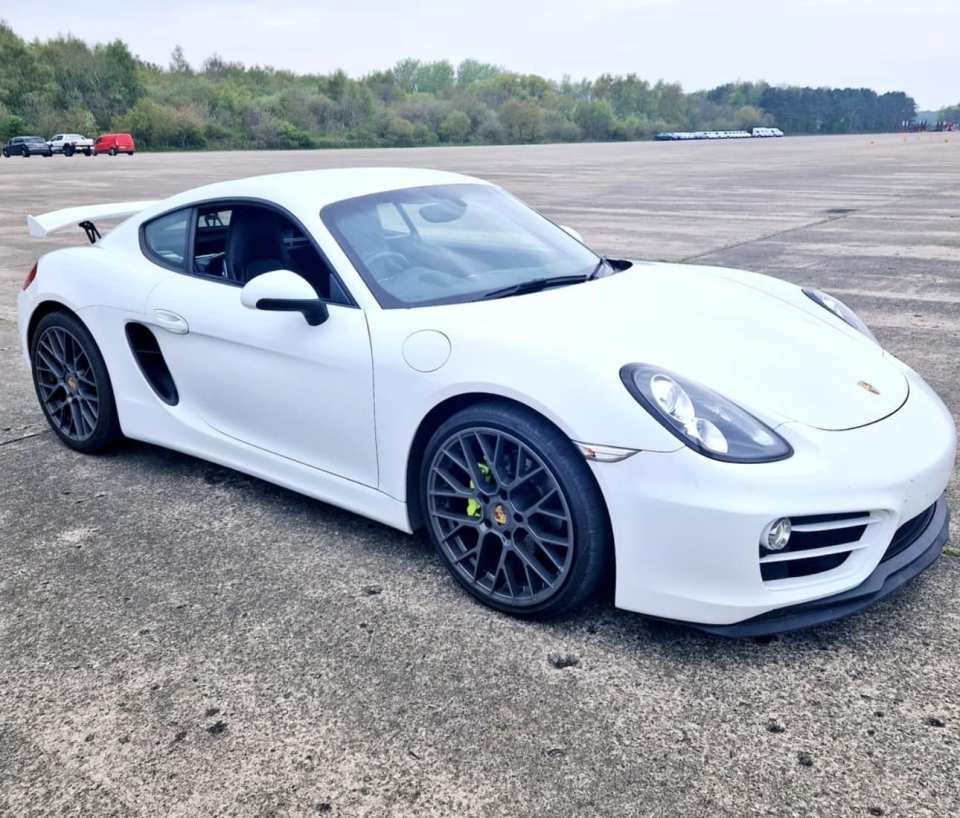 a white porsche sports car is parked on a runway