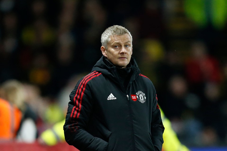 a man wearing an adidas jacket stands in front of a crowd