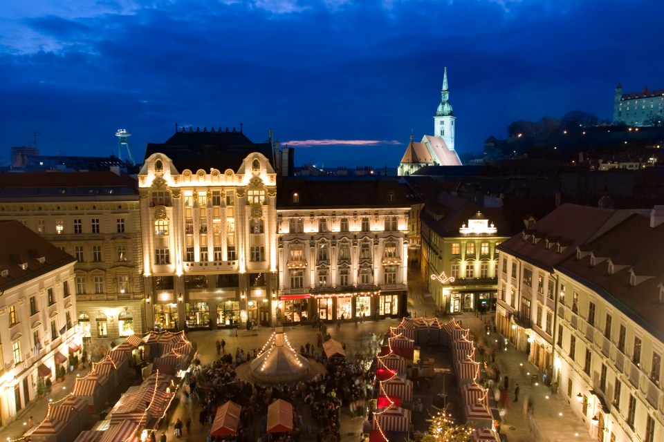 an aerial view of a city at night with a church in the background