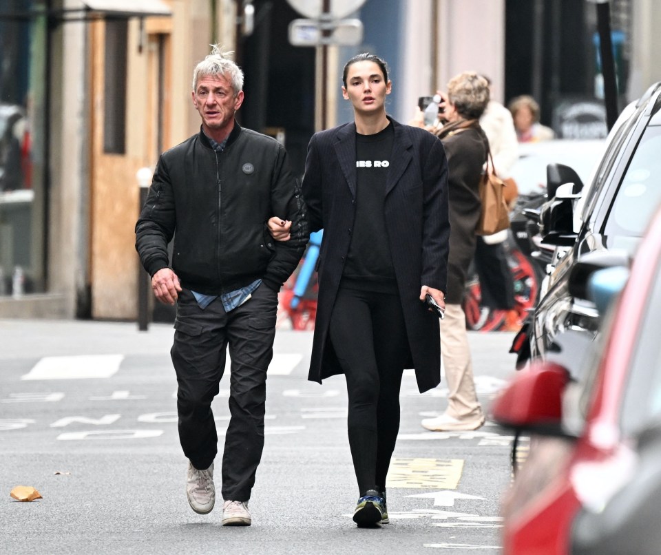 a man and a woman are walking down a street and the woman is wearing a sweatshirt that says i 'm no