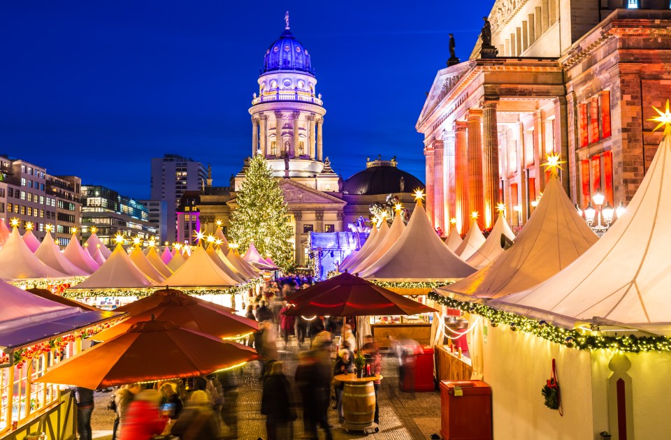a christmas market with a large building in the background