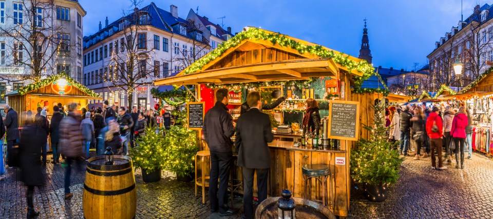 a man stands at a bar at a christmas market