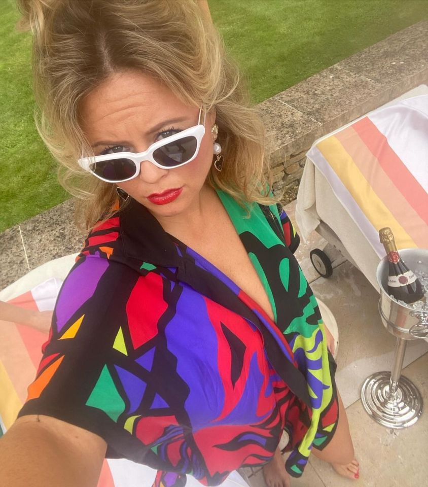 a woman wearing sunglasses is standing next to a bucket of champagne