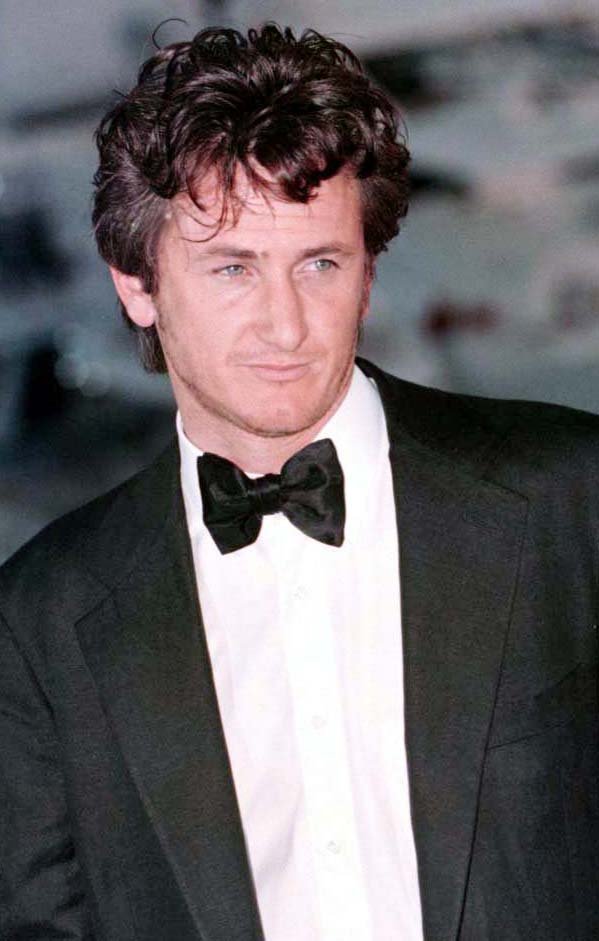 a man in a tuxedo and bow tie looks at the camera