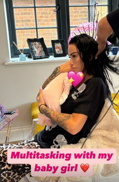 a woman is multitasking with her baby girl
