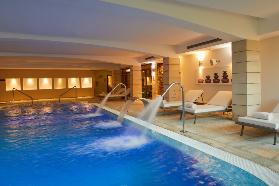 a large indoor swimming pool with jets coming out of it