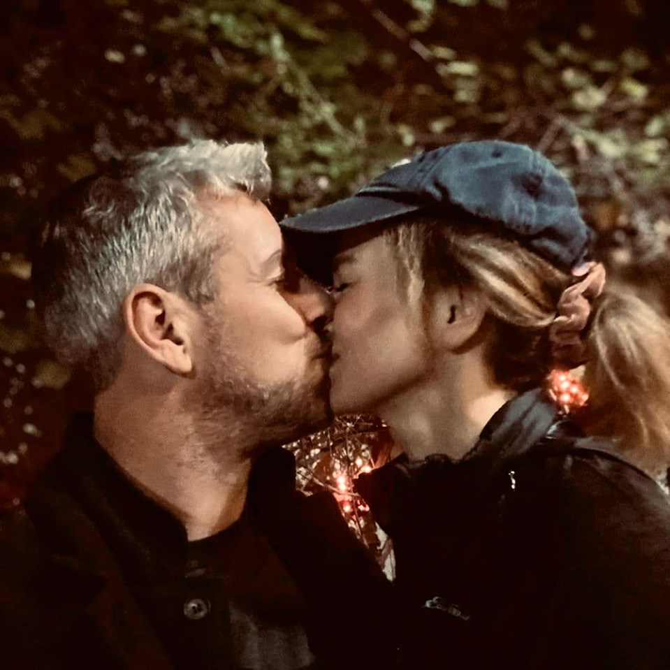 a man and a woman are kissing and the woman is wearing a blue hat