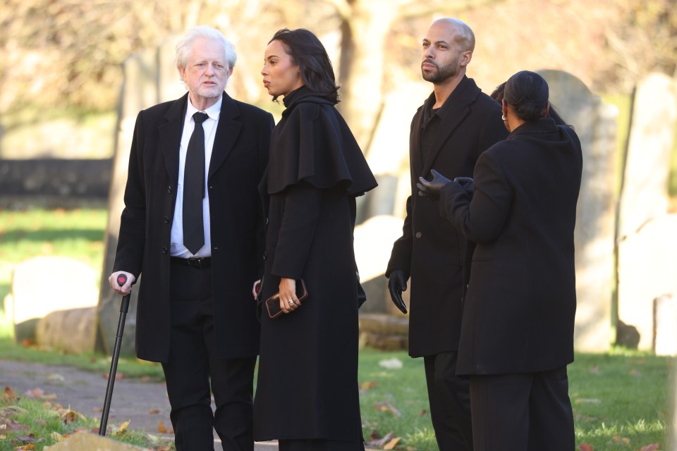 a man with a cane walks with a group of people