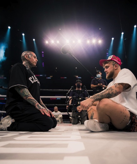 two men are kneeling in a boxing ring with one wearing a shirt that says cla